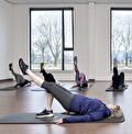 Deelnemers voeren Pilates-oefeningen uit op de mat voor een sterke core bij SportCentrum Prengerhoekman.